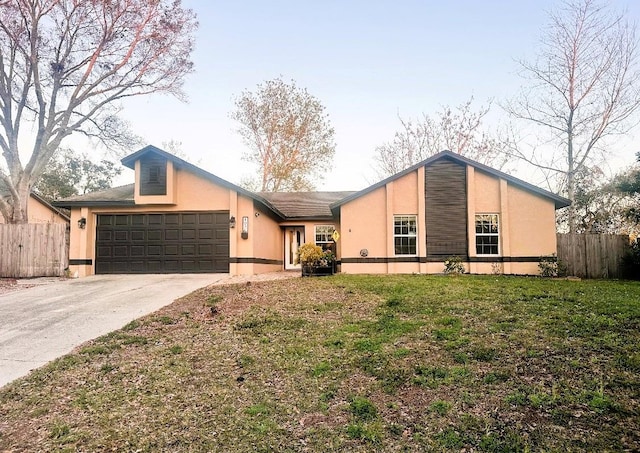 mid-century inspired home featuring a garage, fence, a front lawn, and concrete driveway