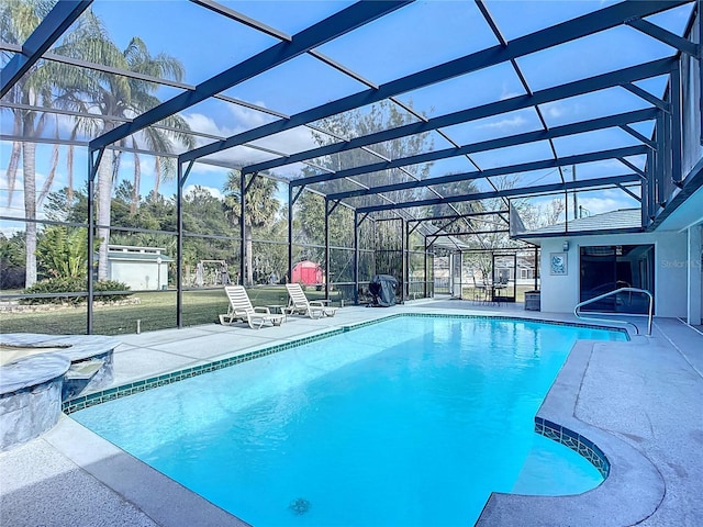 view of pool with a patio area and glass enclosure