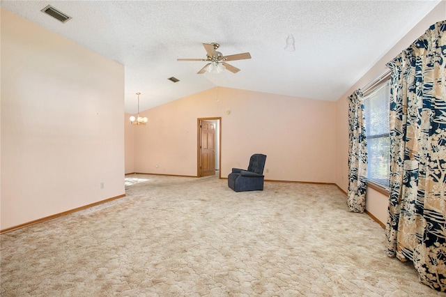 interior space with a textured ceiling, ceiling fan with notable chandelier, light carpet, and vaulted ceiling