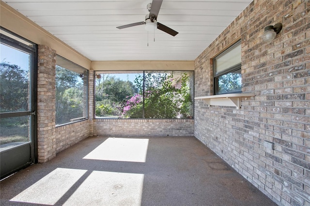 unfurnished sunroom with ceiling fan