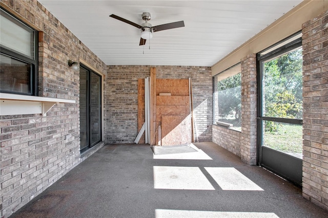 unfurnished sunroom featuring a wealth of natural light and ceiling fan