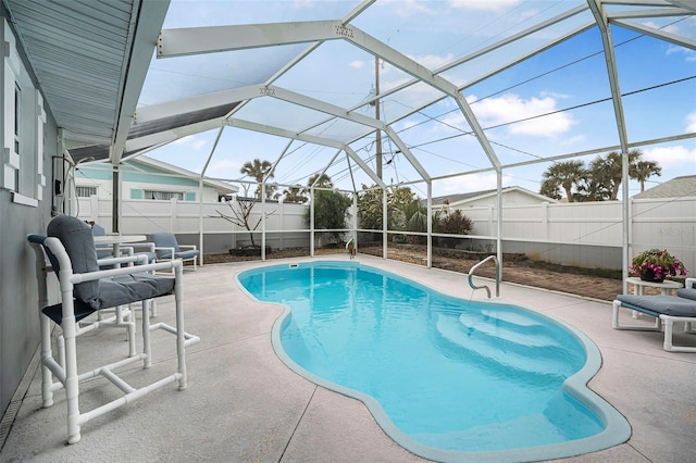 view of pool featuring glass enclosure and a patio area