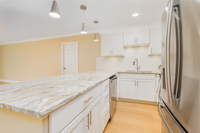 kitchen featuring decorative light fixtures, appliances with stainless steel finishes, sink, and white cabinetry