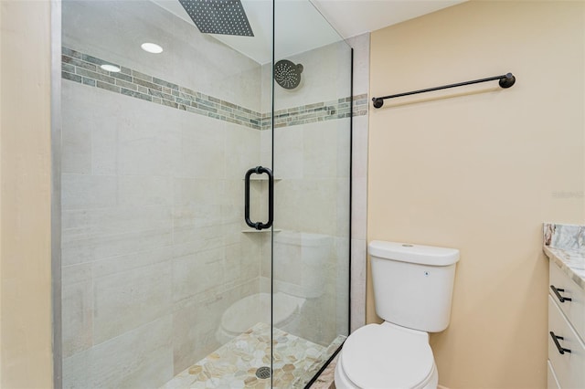 bathroom featuring toilet, an enclosed shower, and vanity