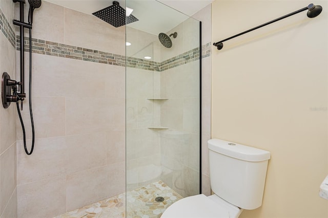 bathroom featuring toilet and a tile shower