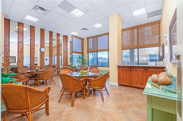 tiled dining area with a drop ceiling