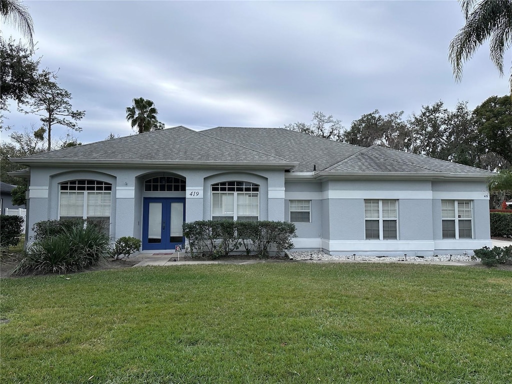 ranch-style home featuring a front yard and french doors