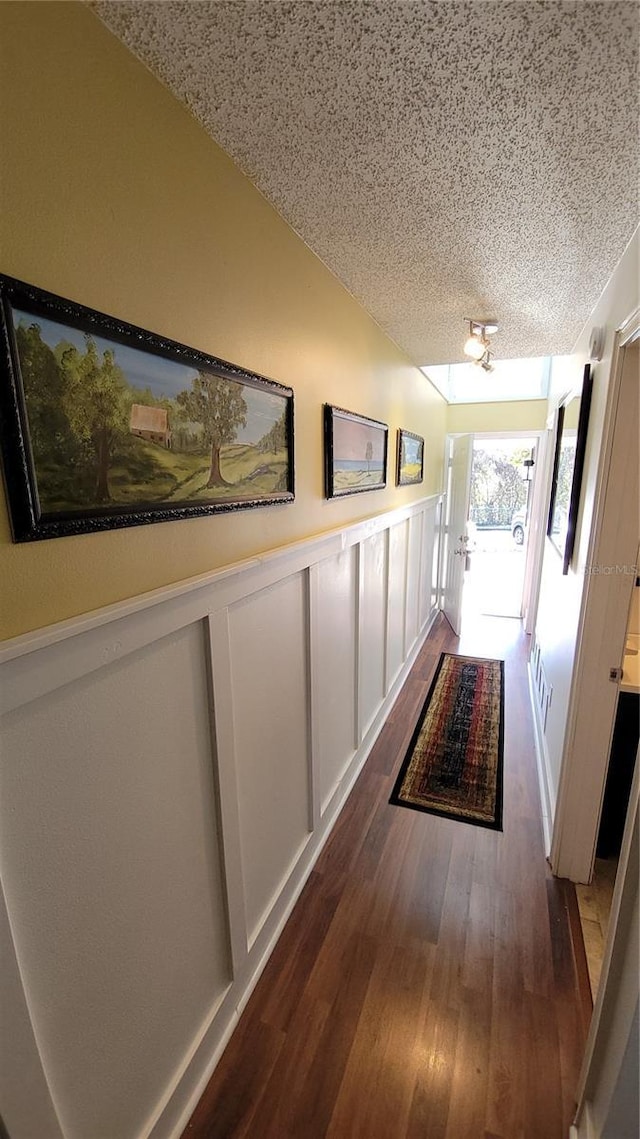 hallway featuring a textured ceiling and dark hardwood / wood-style floors