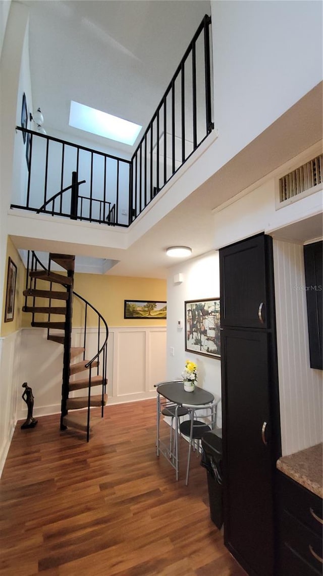 interior space with a high ceiling and hardwood / wood-style flooring