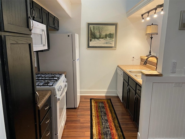 kitchen featuring sink, dark hardwood / wood-style flooring, and white appliances