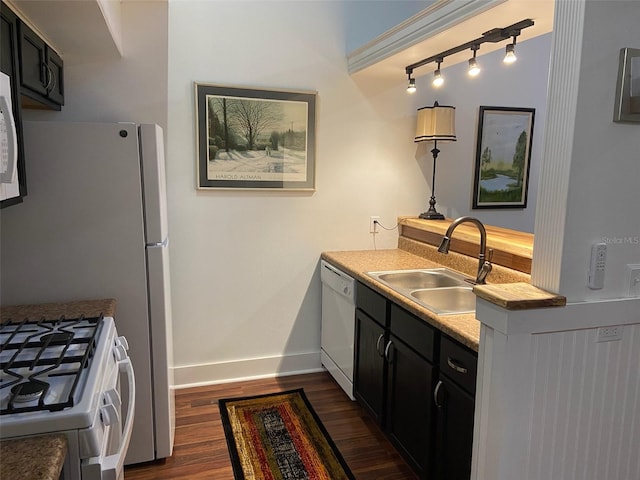 kitchen with sink, dark hardwood / wood-style flooring, and white appliances