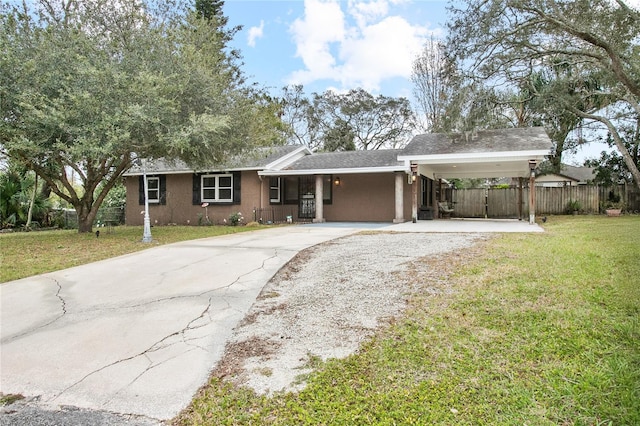 ranch-style home featuring a carport and a front yard