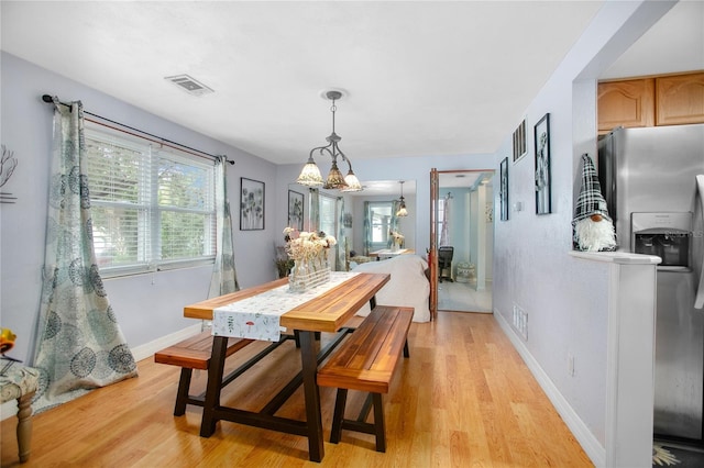 dining area featuring light hardwood / wood-style flooring and a chandelier