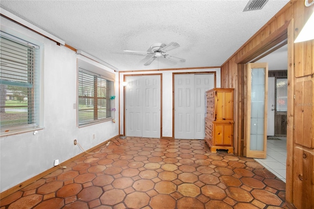 unfurnished bedroom with a textured ceiling, ceiling fan, and ornamental molding