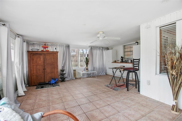 interior space featuring ceiling fan and wood walls