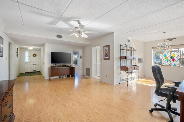 office area featuring ceiling fan with notable chandelier, light hardwood / wood-style floors, and a textured ceiling