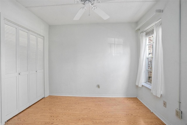 unfurnished bedroom featuring a textured ceiling, a closet, ceiling fan, and light wood-type flooring