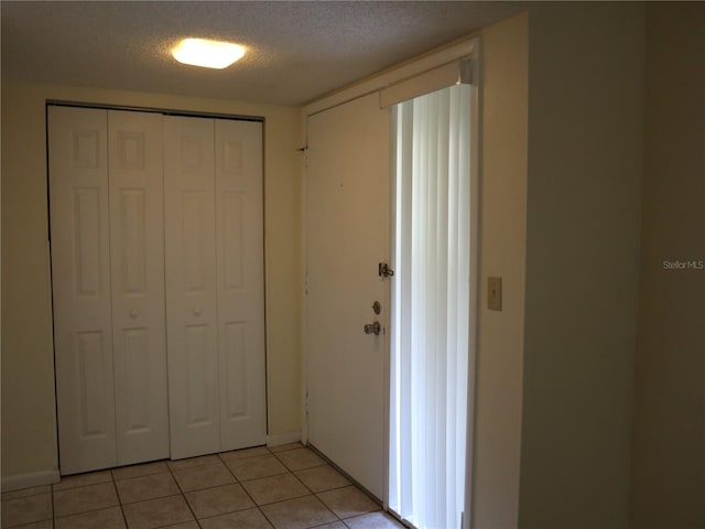 interior space featuring a textured ceiling and light tile patterned floors