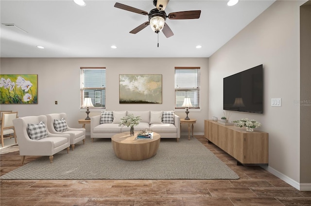 living room featuring ceiling fan and a healthy amount of sunlight