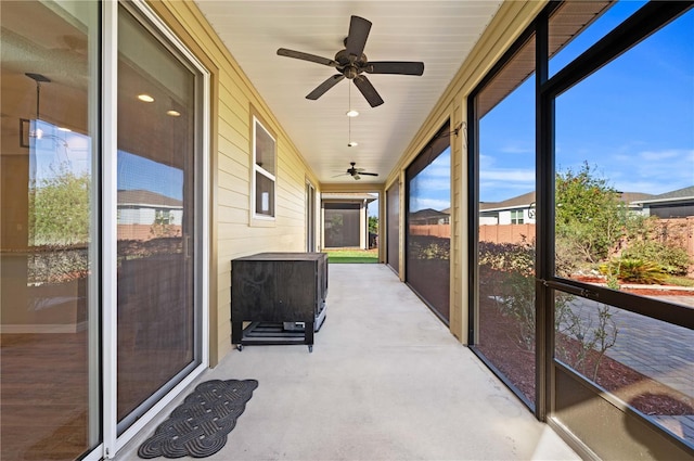 unfurnished sunroom featuring ceiling fan