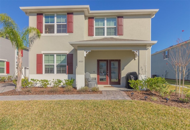 view of front of property featuring french doors and a front lawn