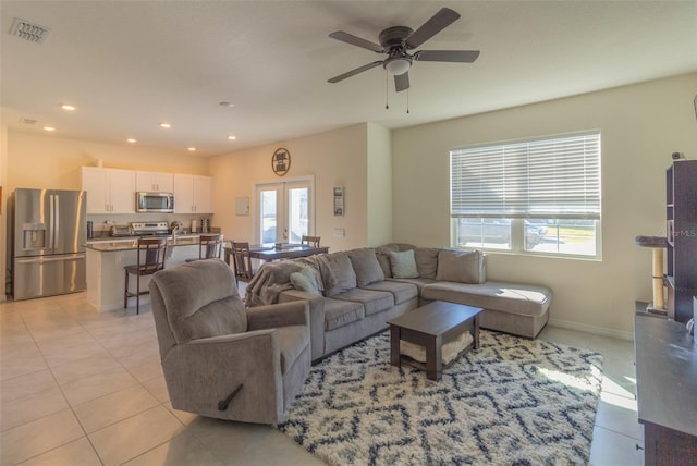 living room with a wealth of natural light, ceiling fan, and light tile patterned flooring