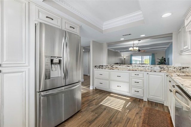 kitchen featuring white cabinetry, appliances with stainless steel finishes, a raised ceiling, and ornamental molding