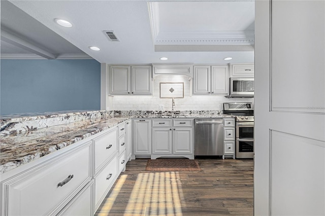 kitchen featuring sink, dark wood-type flooring, appliances with stainless steel finishes, ornamental molding, and white cabinets