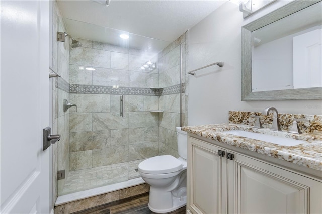 bathroom with hardwood / wood-style flooring, toilet, walk in shower, and vanity