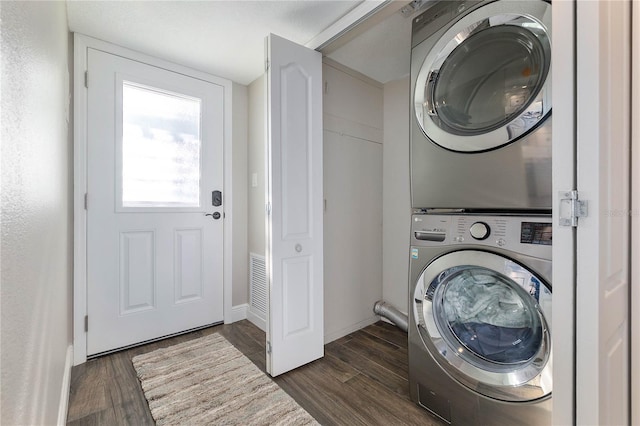 laundry area featuring stacked washer and dryer and dark hardwood / wood-style floors