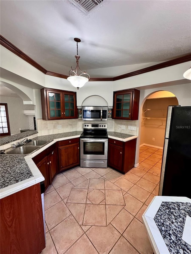 kitchen featuring light tile patterned flooring, stainless steel appliances, sink, and decorative light fixtures