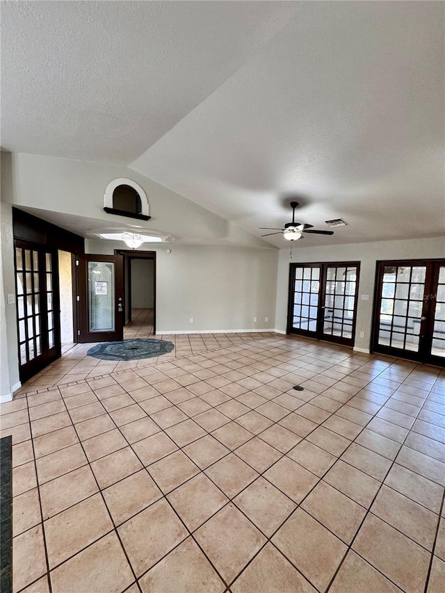 tiled spare room featuring french doors, a textured ceiling, ceiling fan, and lofted ceiling