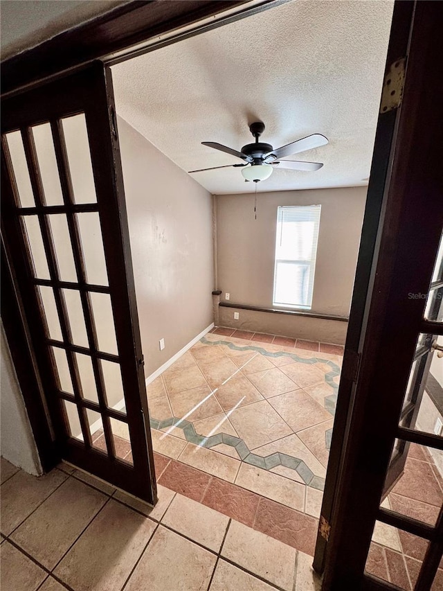 unfurnished room with a textured ceiling, tile patterned floors, and ceiling fan