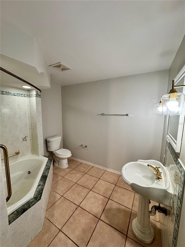 bathroom featuring tile patterned flooring, tiled shower / bath combo, and toilet