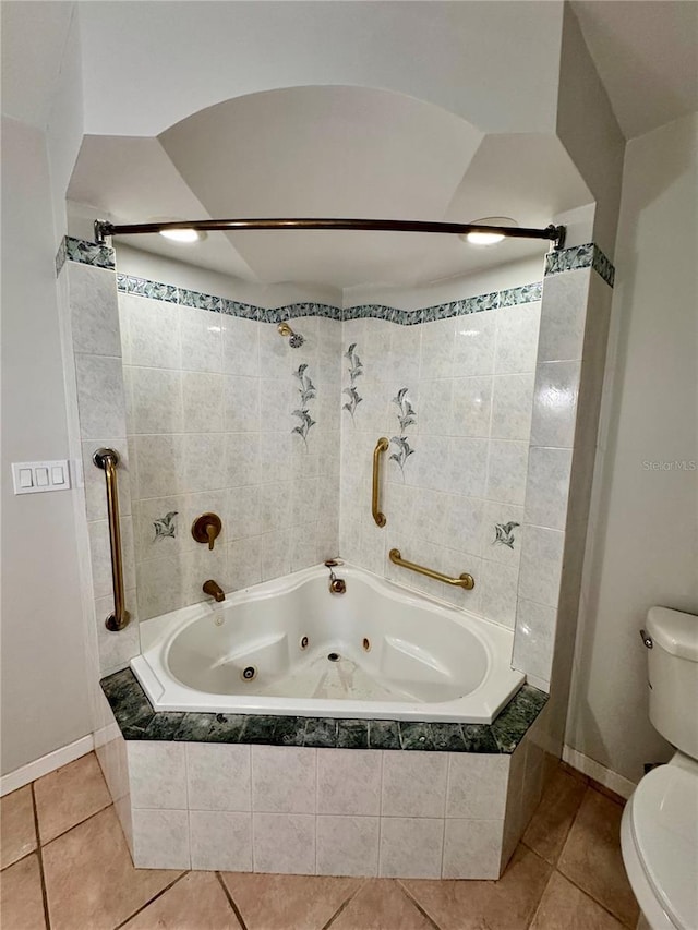 bathroom with tile patterned floors, toilet, and tiled shower / bath