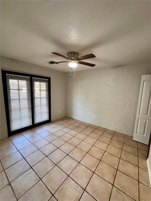 tiled spare room featuring ceiling fan and a textured ceiling