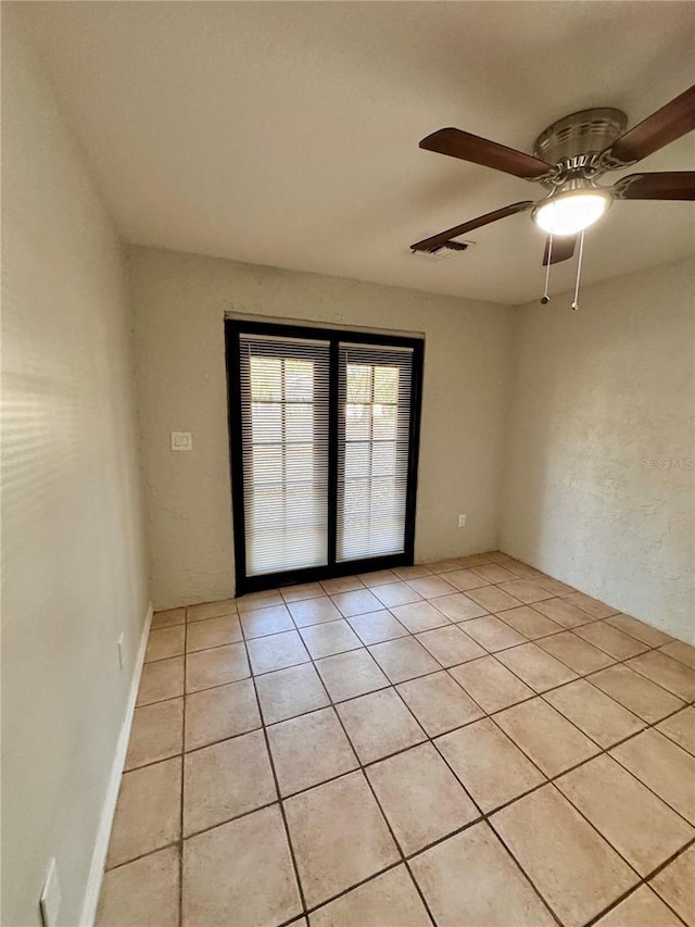 tiled empty room with ceiling fan