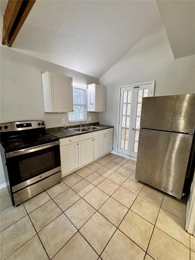 kitchen featuring lofted ceiling, french doors, sink, white cabinetry, and stainless steel appliances