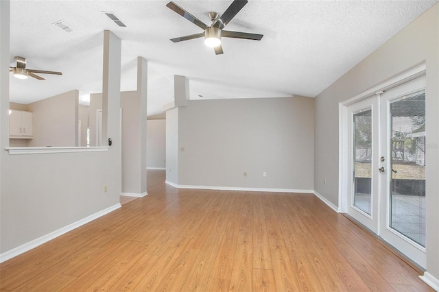 unfurnished living room with light hardwood / wood-style floors, ceiling fan, french doors, a textured ceiling, and lofted ceiling