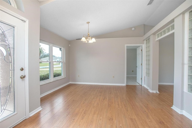 interior space with light hardwood / wood-style floors, an inviting chandelier, and vaulted ceiling