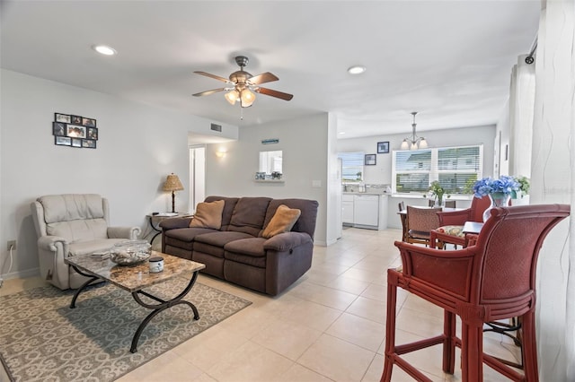 living room with ceiling fan with notable chandelier