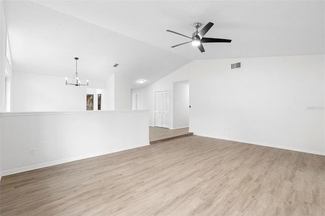 unfurnished living room with light hardwood / wood-style floors, vaulted ceiling, and ceiling fan with notable chandelier