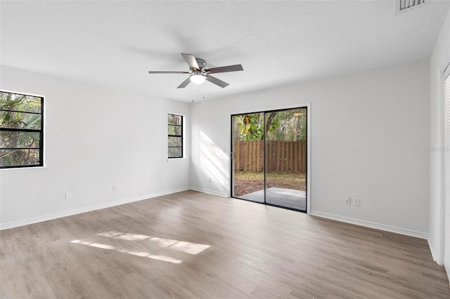 empty room featuring light hardwood / wood-style floors, ceiling fan, and a textured ceiling