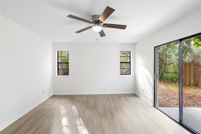 unfurnished room featuring a textured ceiling, ceiling fan, light hardwood / wood-style floors, and a healthy amount of sunlight