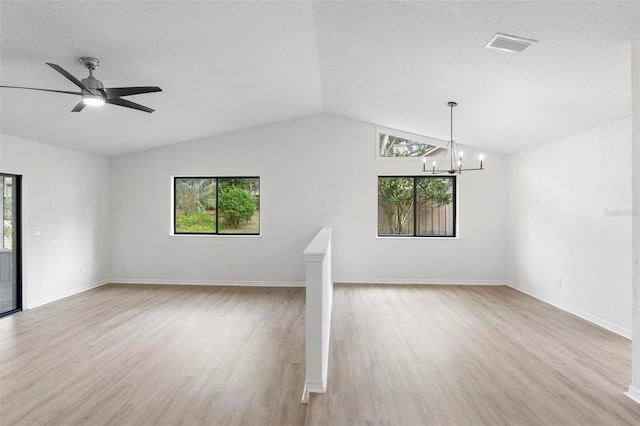 unfurnished living room featuring lofted ceiling, light wood-type flooring, and plenty of natural light