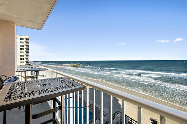 balcony featuring a water view and a view of the beach