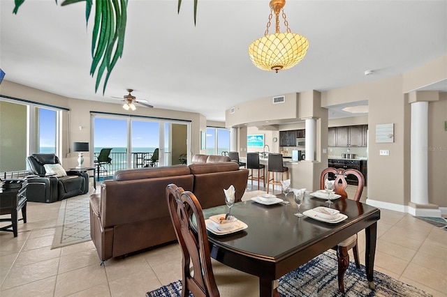 tiled dining area with ceiling fan, plenty of natural light, and sink