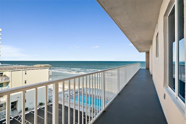 balcony featuring a water view and a beach view