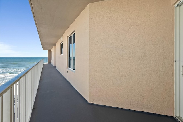 balcony featuring a water view and a beach view