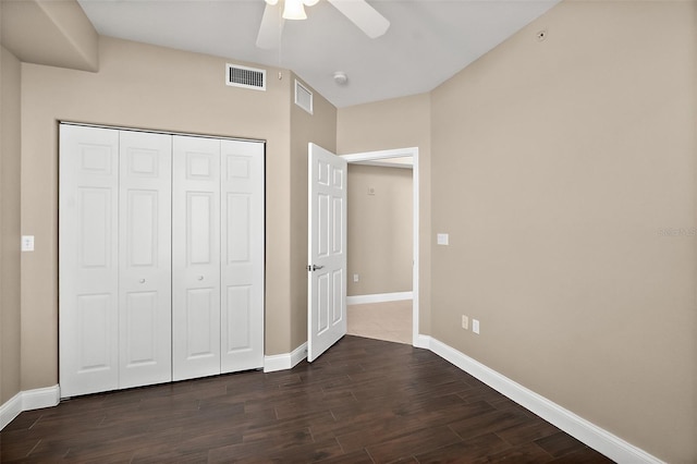 unfurnished bedroom with ceiling fan, dark hardwood / wood-style flooring, and a closet